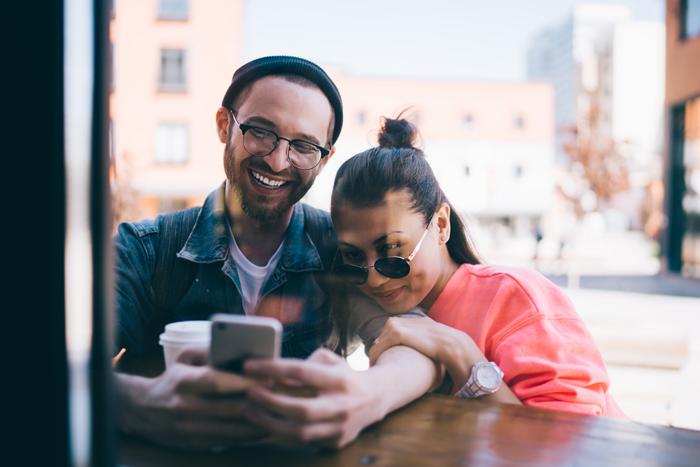 Köp mobilskal hos Phonelife Youthful hipster guys watching positive video vlog during networking social website via smartphone technology connecting to 4g, happy male and female bloggers reading funny content publication