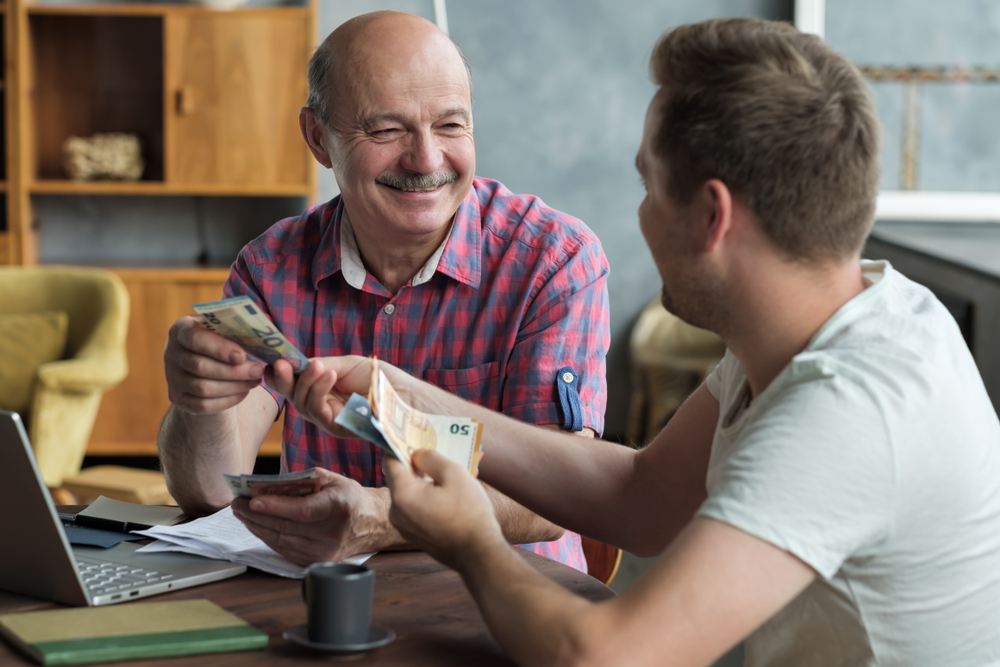 Så startar du en pop-up-butik enkelt Elderly father lends money to his adult son. He helps his child deal with financial problems sitting in the living room